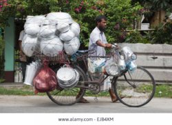 Vendor carrying pots on bicycle cooch behar west bengal india EJB4XM